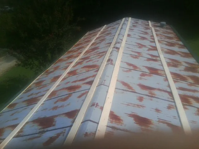 Rusted metal roof panels with new wood purlins before replacement — Storm Damage Roof Repair in Onset by Roofing Brothers