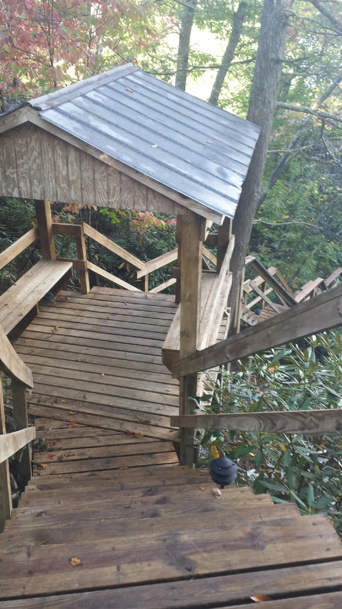 Metal roofed shelter over wooden steps on a wooded walkway — Skylight Repair & Installation work by our crew in Onset