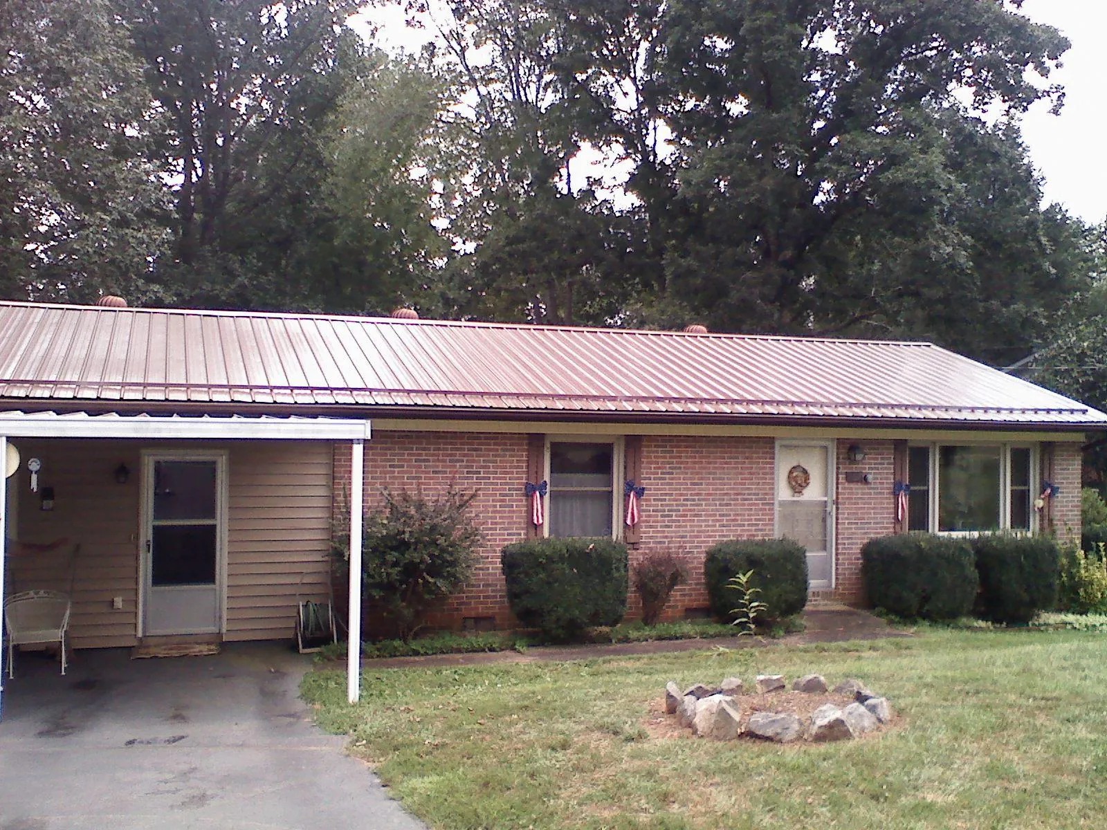 Bronze metal roof and carport on a brick ranch home — Roof Repair work by our crew in Onset